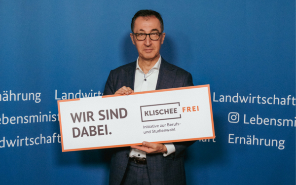 Cem Özdemir mit einem Schild der Initiative Klischeefrei