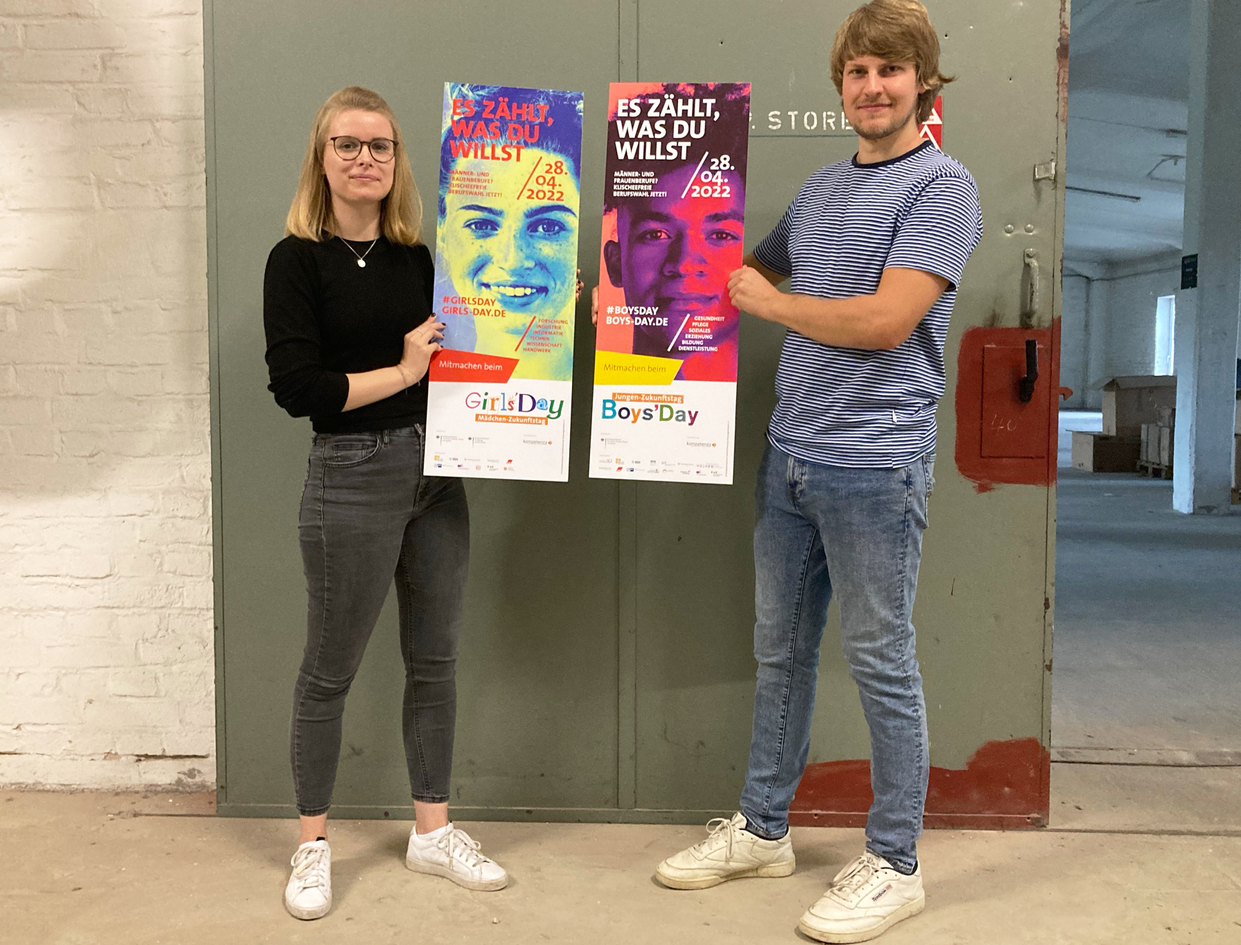 Junger Mann und junge Frau mit Plakaten
