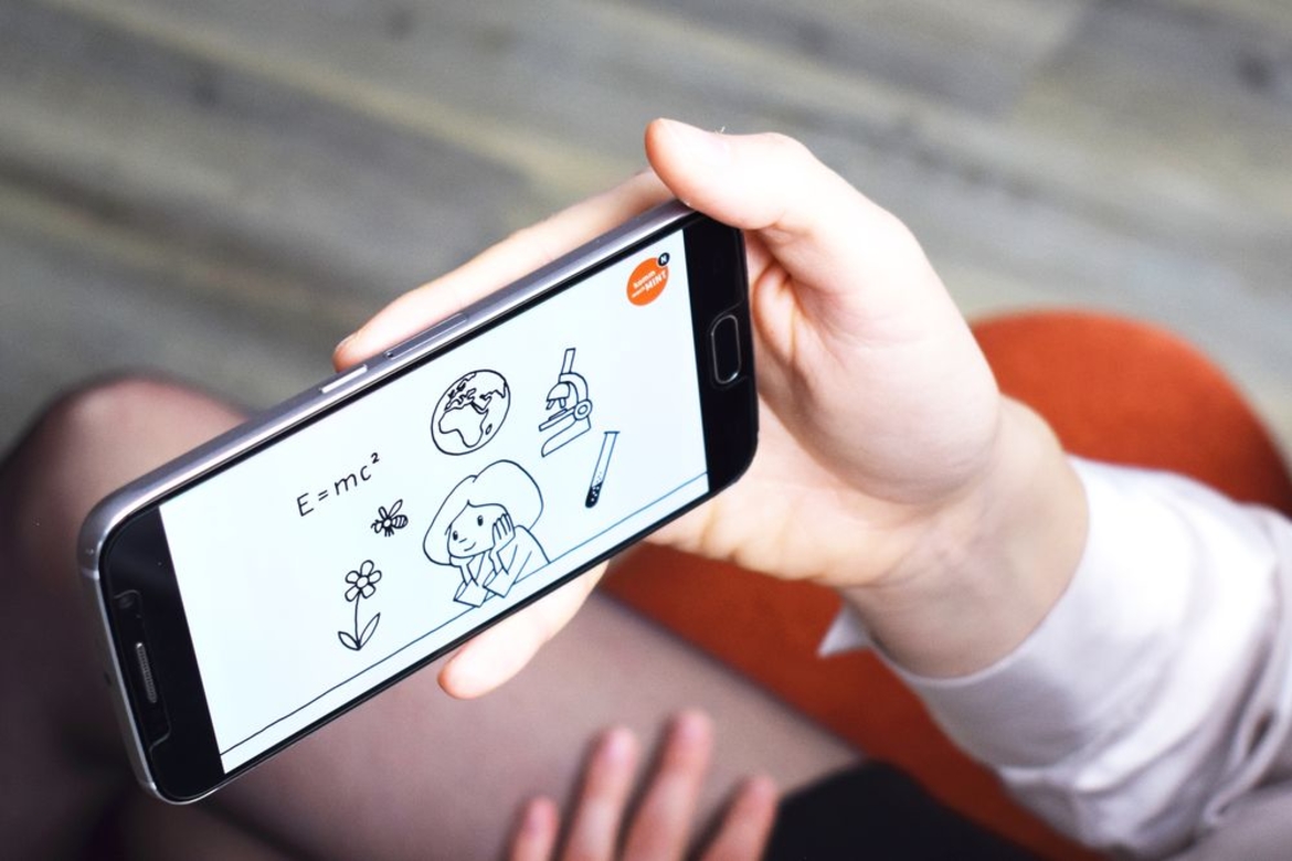 Berufe-Videos Komm, mach MINT Junge Frau schaut ein Berufe-Video auf dem Smartphone an
